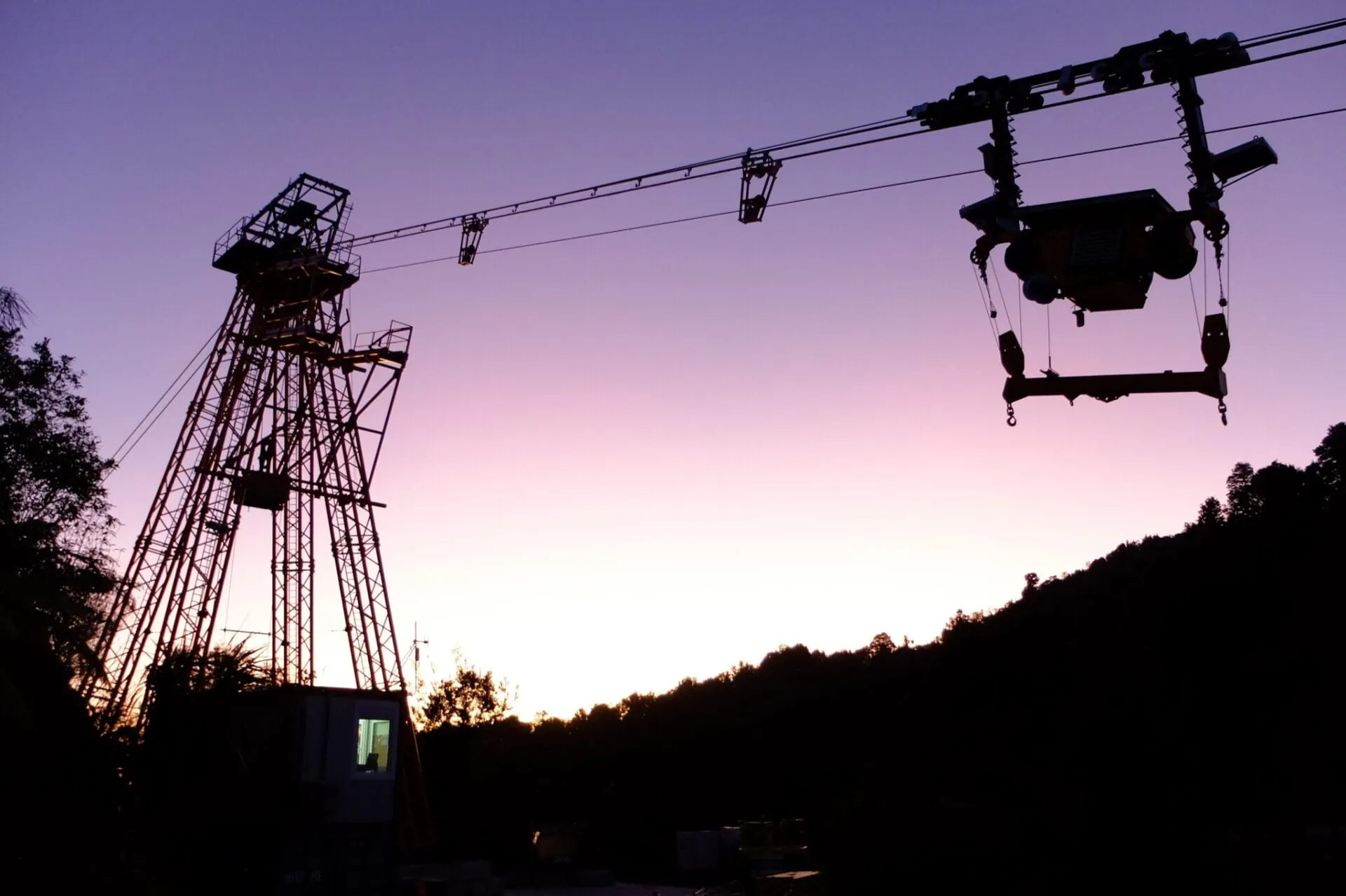 Seilkrananlage von LCS Cable Cranes als Silhouette im Abendlicht