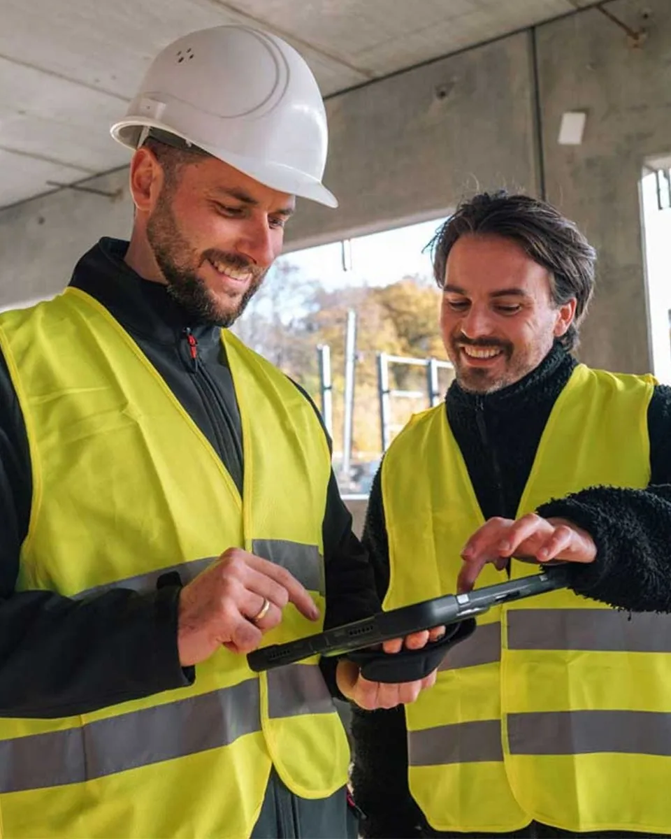 Die beiden DV-Gründer Sebastian Kalberg und Tim Frauenrath auf der Baustelle, gemeinsam am Tablet